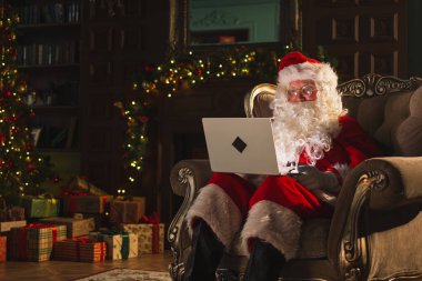 Mutlu noeller. Bilgisayarlı Noel Baba, çocuklardan gelen mektupları okuyor ve internetten hediyeler alıyor. Noel arifesinde bilgisayarlı Noel Baba. Noel Baba 'nın posta hediyeleri. Kış Tatili Kutlamaları
