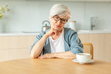 Kendine güveni tam orta yaşlı Avrupalı bir kadının portresi. Evde gülümseyen 60 'lı yaşlarda olgun bir kadın. Mutlu, çekici, son sınıf öğrencisi, kamera görüntüsü, yüz portresi. Mutlu insanlar.