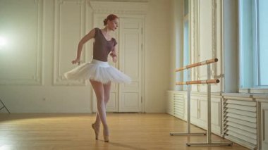 Bale dersinde etekli balerin dans ederek bale yapıyor. Dans stüdyosundaki genç klasik dansçı kadın. Bale sınıfı eğitimi. Bale okulunda dans provası yapan sanatçı kız.