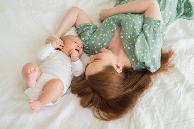 Evde mutlu bir aile. Anne kucağında küçük bir bebek, sütü şişeden besliyor. Yeni doğmuş bebek kız bebek süt içiyor. Bebeği emziren anne. Annelik mutlu çocuk