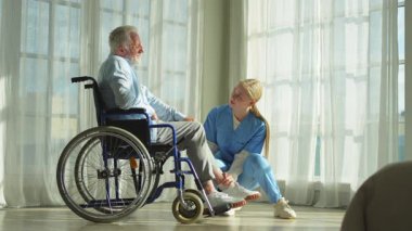 Emeklilik sağlık hizmetlerine destek ol. Hemşire tekerlekli sandalyedeki yaşlı adama yardım ediyor. Hasta ve kadın tıbbi bakım için huzurevinde. Engelli insanlar için tekerlekli sandalyede felçli bir adama bakan hemşire.