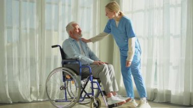 Emeklilik sağlık hizmetlerine destek ol. Hemşire tekerlekli sandalyedeki yaşlı adama yardım ediyor. Hasta ve kadın tıbbi bakım için huzurevinde. Engelli insanlar için tekerlekli sandalyede felçli bir adama bakan hemşire.