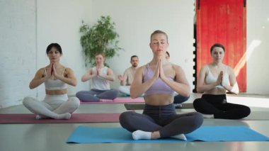 Yoga farkındalığı meditasyonu. Yoga sağlık farkındalığı meditasyonu için stüdyoda egzersiz yapan bir grup sporcu. Nilüfer çiçeğinde oturup yoga yapan erkek kadınlar meditasyon yapıyor.