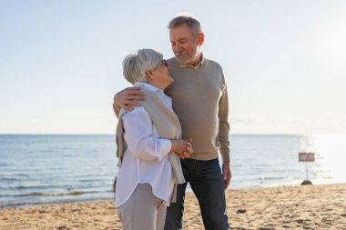 Yaşlı bir çift kumsalda yürüyüş yaparken kucaklaşıp eğleniyorlar. Yaşlı karı şefkatle kucaklaşıyor aşk tatlı bir bağın tadını çıkarıyor. Büyükannem ve büyükbabam birlikte. Aile anı aşkı