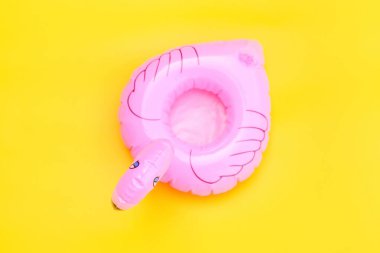 Yaz kumsalı kompozisyonu. Sarı arka planda pembe şişirilebilir flamingo ile basit bir tasarım. Havuz şamandırası partisi, ünlü modası konsepti. Düz görünüm kopyalama alanı