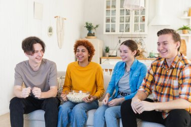 Bir grup arkadaş televizyonda futbol maçı izliyorlar. Memlekette zaferi kutlayan futbol taraftarları. Arkadaşlık sporu eğlence konsepti. Çeşitli arkadaşlar evde birlikte eğleniyorlar.