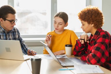 Takım çalışması beyin fırtınası. Çeşitli meslektaşlar birlikte çalışarak mali istatistikleri tartışırlar. Bir grup mutlu modern insan yaratıcı ofiste oturmuş iş tartışıyorlar. Genç profesyonel takım