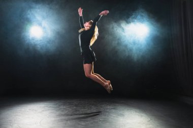 Siyah arka planda dumanla poz veren çağdaş kadın dansçı. Yetişkin kadın sanatçı ifade ile dans ediyor. Modern balerin karanlıkta dans ediyor. Tutku karanlıkta dans eder. Esneklik dengesi