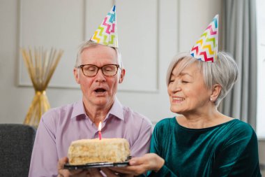 Bir dilek tut. Parti şapkalı son sınıf aile çifti evde birlikte doğum günü kutluyor. Yaşlı adam doğum günü pastasında yanan mumları üflüyor. Yaşlı kadın kocana mutlu yıllar diliyor.