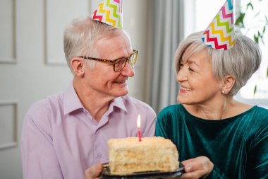 Bir dilek tut. Parti şapkalı son sınıf aile çifti evde birlikte doğum günü kutluyor. Yaşlı kadın doğum günü pastasında yanan mumları üflüyor. Yaşlı adam karısına mutlu yıllar diliyor.