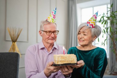Bir dilek tut. Parti şapkalı son sınıf aile çifti evde birlikte doğum günü kutluyor. Yaşlı adam doğum günü pastasında yanan mumları üflüyor. Yaşlı kadın kocana mutlu yıllar diliyor.