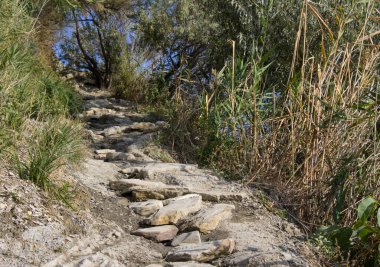 Dağın dik çıkıntıları taş basamaklarda