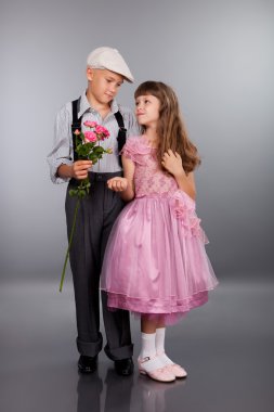 Çocuk bir çiçek kız için verir.