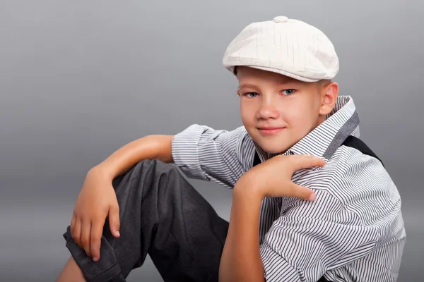 Vecchio ragazzo stile seduto su sfondo grigio — Foto Stock