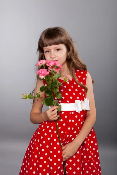 Lächelndes kleines Mädchen mit Blumen — Stockfoto