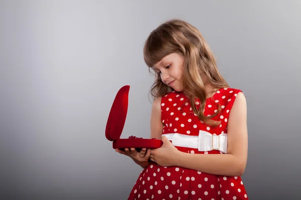 Onu mevcut tutan Kırmızı elbiseli küçük kız — Stok fotoğraf