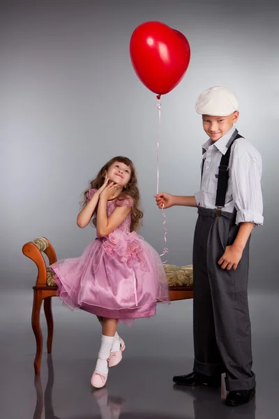Çocuk kırmızı bir balon kıza verir. — Stok fotoğraf