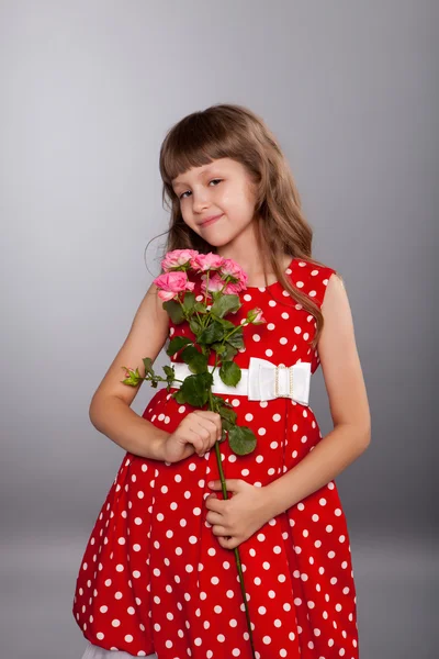 Lächelndes kleines Mädchen mit Blumen — Stockfoto