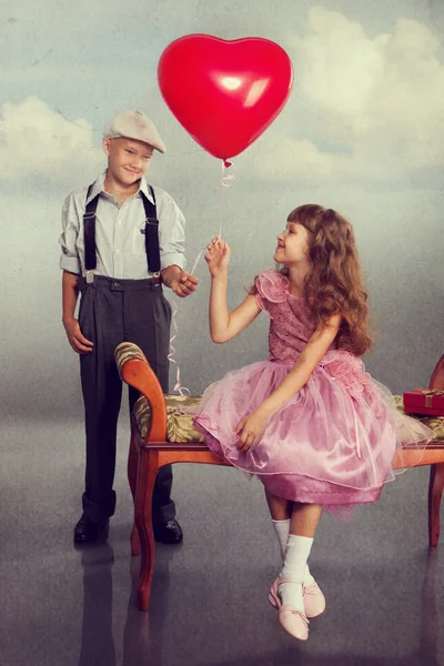 Le garçon donne un ballon rouge à la fille — Photo