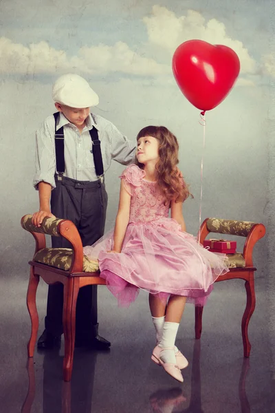 Der Junge schenkt dem Mädchen einen roten Luftballon — Stockfoto