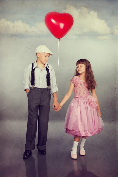 Niedliche Kinder gehen mit einem roten Luftballon — Stockfoto