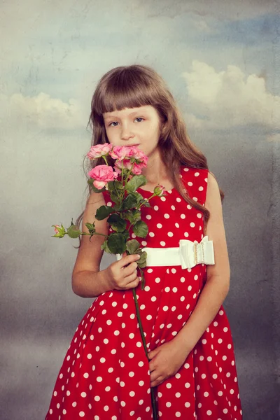 Küçük kız çiçek tutan gülümseyerek — Stok fotoğraf