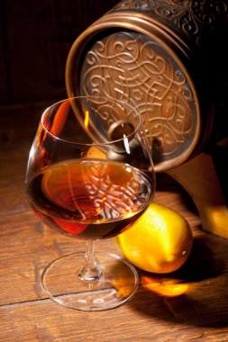 Bardak konyak ahşap arka plan üzerinde limonlu