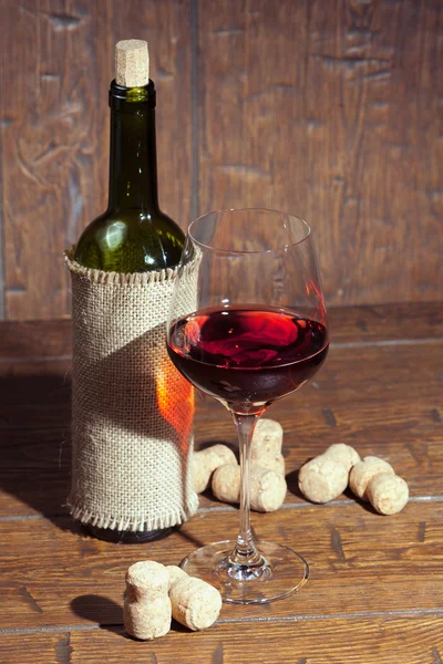 Botellas de vino con vidrio sobre fondo de madera — Foto de Stock