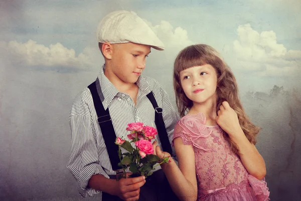 Pojken ger en blomma till flickan — Stockfoto