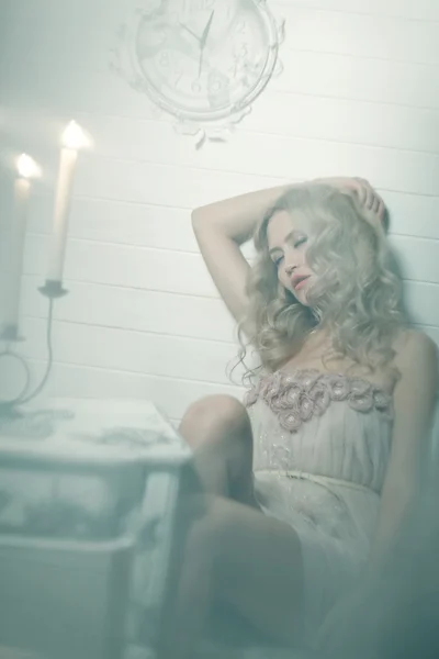 Hübsche blonde Frau in einem weißen Inneren — Stockfoto