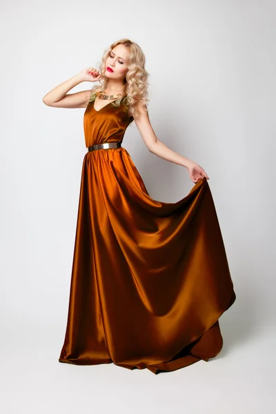 Beautiful woman model posing in orange dress — Stock Photo, Image