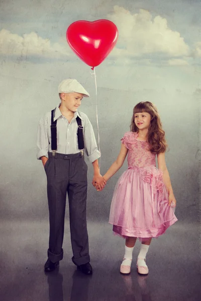 Милые дети ходят с красным шаром Стоковое Изображение
