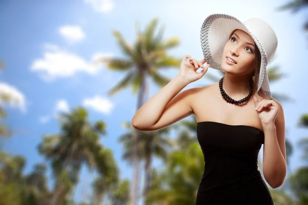 Tropik sahilde şapka tutan kadın — Stok fotoğraf