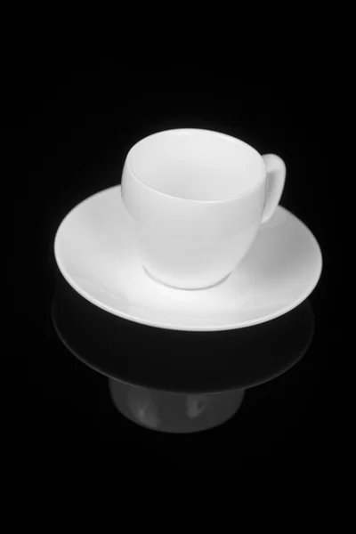 Witte cup op glanzend zwarte achtergrond — Stockfoto