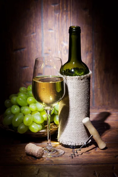 Wine bottles with glass on wooden background Royalty Free Stock Photos