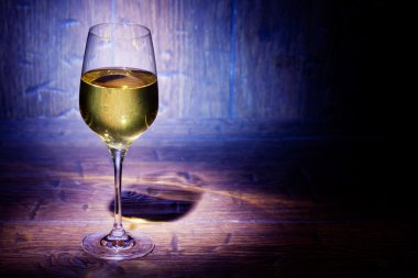 Mavi ahşap arka plan üzerinde şarap kadehi