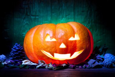 Yeşil ahşap arka plan üzerinde korkunç Cadılar Bayramı Balkabağı