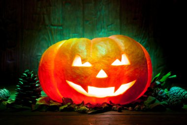 Yeşil ahşap arka plan üzerinde korkunç Cadılar Bayramı Balkabağı