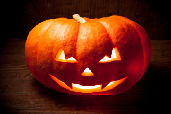Strašidelné Halloween dýně na staré dřevěné pozadí — Stock fotografie