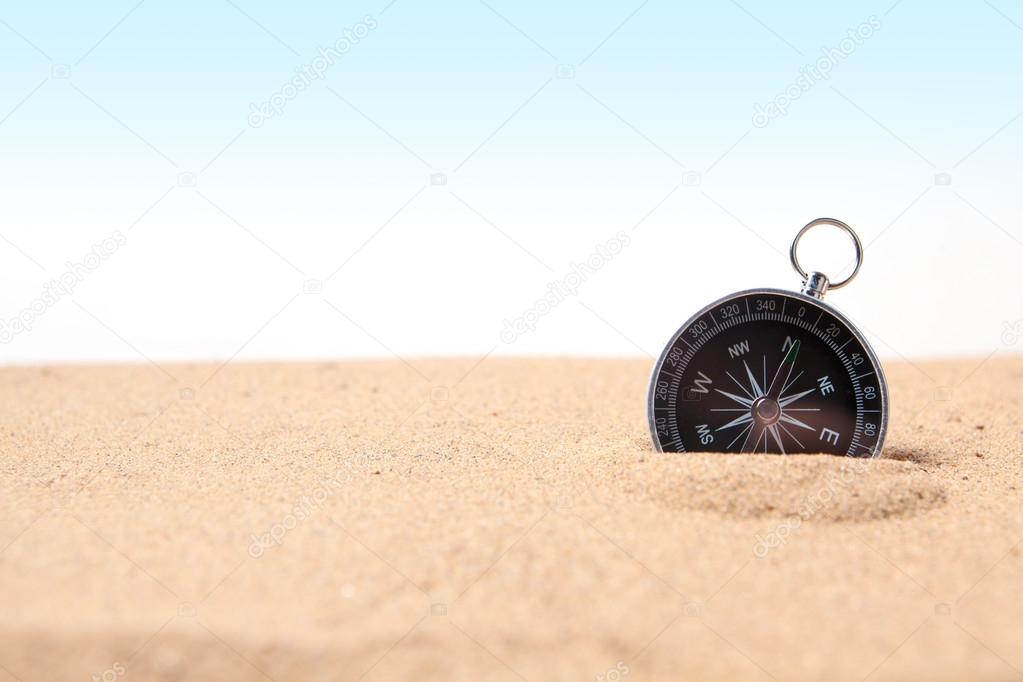 Compass on the sea sand