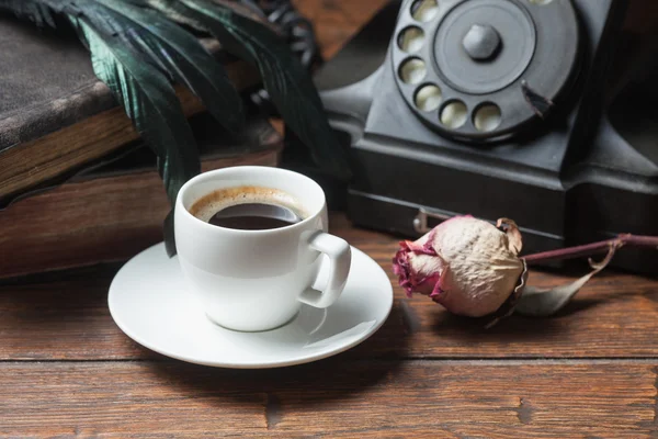 Cup of coffee, dry rose and old telephone — Stock Photo, Image