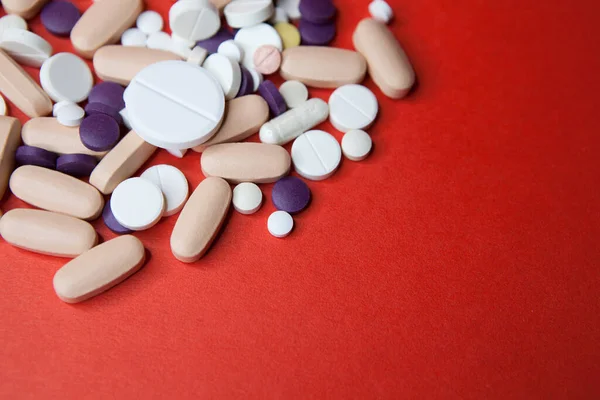 Различные таблетки макрос на красном фоне. Вид сверху — стоковое фото