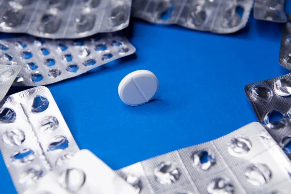 Empty used blister package and pill on blue background — Stock Photo, Image