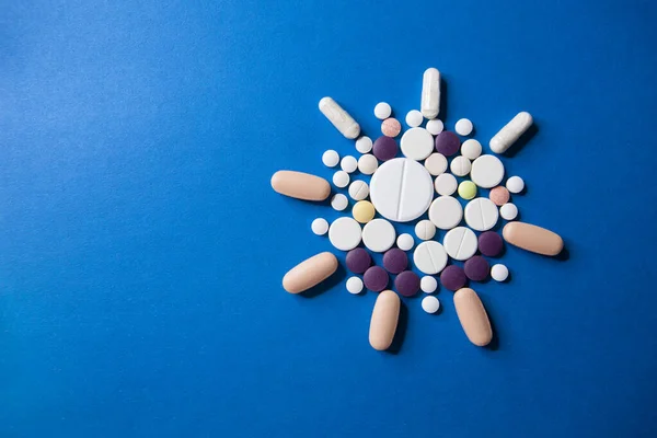 Covid-19 corona virus cure. Colorful medical pills on blue background for ncov-19 diseases treatment. — Stock Photo, Image