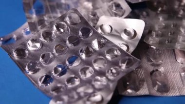 Boş şişkinlik paketi ve mavi arka planda hap