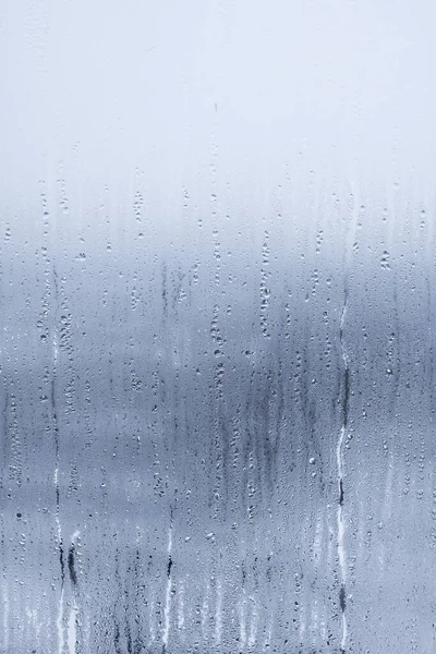 Regentropfen auf Fensterglas. Abstrakter Hintergrund. Blauer Ton — Stockfoto