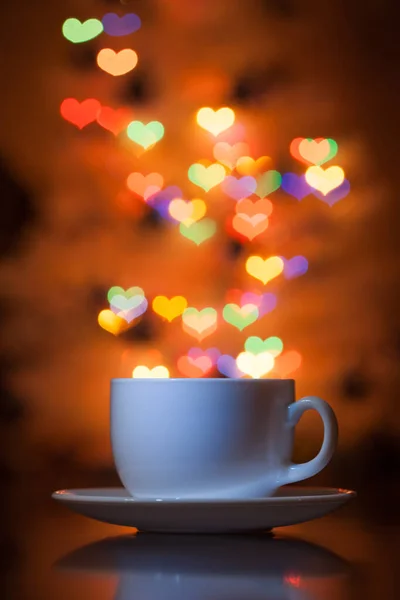 Taza de té en el fondo bokeh en forma de corazones — Foto de Stock