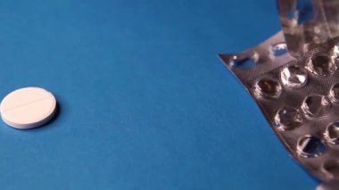 Boş şişkinlik paketi ve mavi arka planda hap