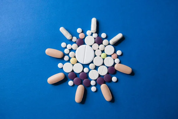 Covid-19 corona virus cure. Colorful medical pills on blue background for ncov-19 diseases treatment. — Stock Photo, Image