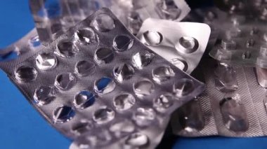 Boş şişkinlik paketi ve mavi arka planda hap